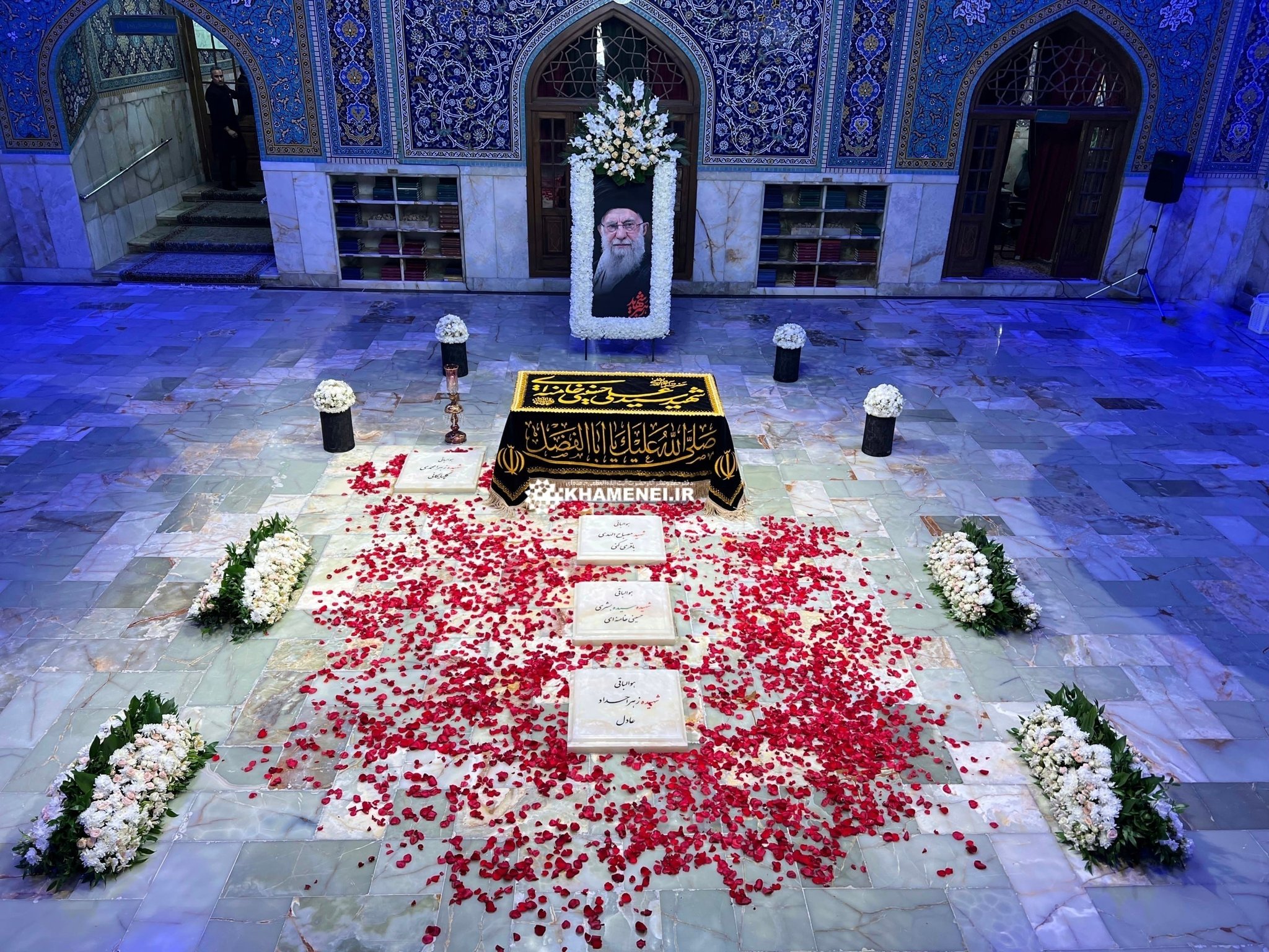 His grave covered with rose petals and flowers